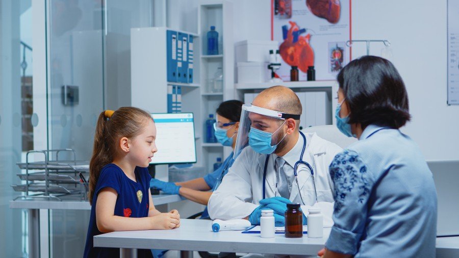 little girl speaking with doctor consultation covid-19 pediatrician specialist medicine with protection mask providing health care services treatment-examination hospital cabinet