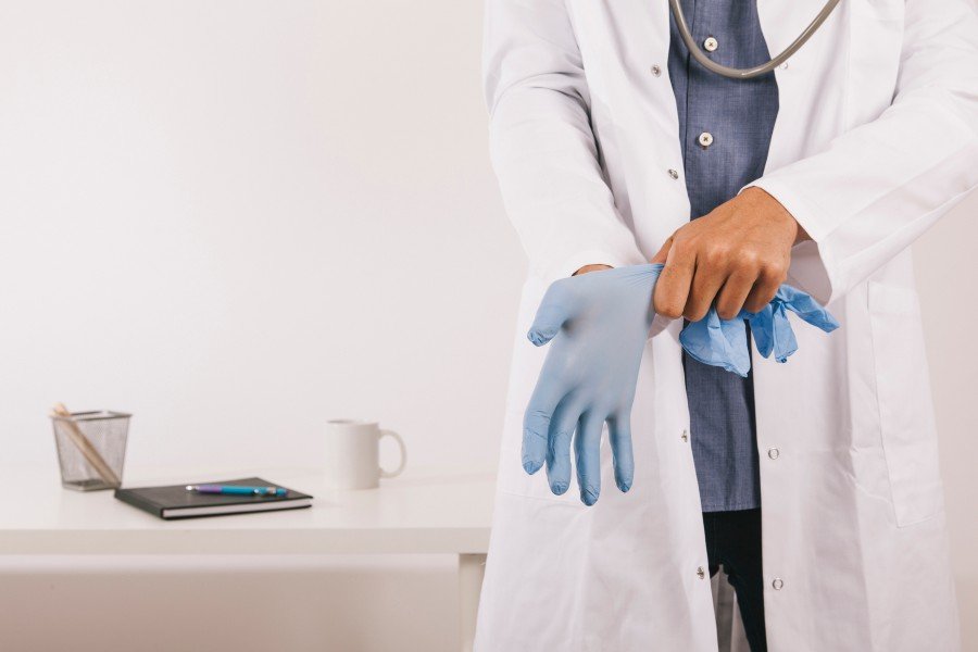 Urologist wearing medical gloves in a clinical setting