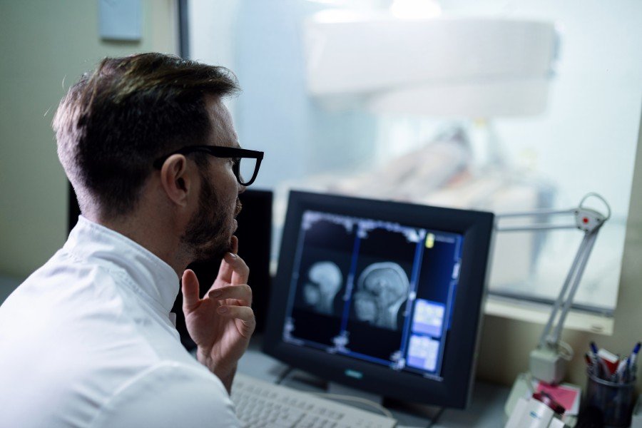 Radiology doctor examining an MRI scan on a computer monitor in a hospital